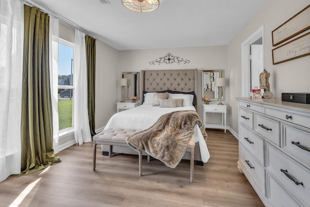 bedroom with light wood-style flooring and baseboards