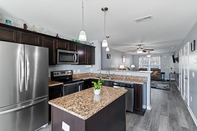 kitchen with a peninsula, a sink, visible vents, open floor plan, and appliances with stainless steel finishes