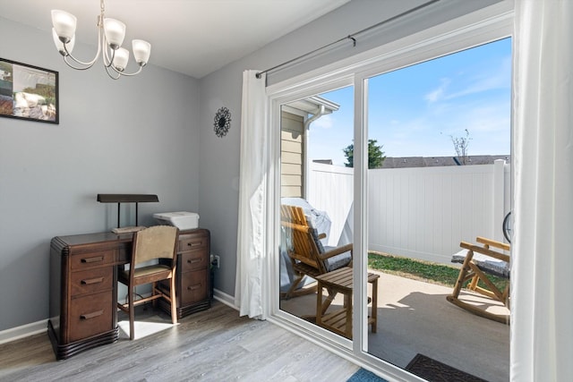 home office featuring a chandelier, baseboards, and wood finished floors