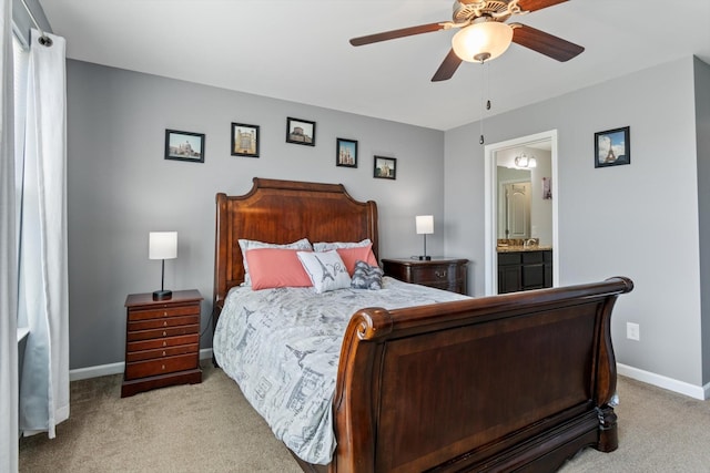 carpeted bedroom featuring ceiling fan, ensuite bath, and baseboards