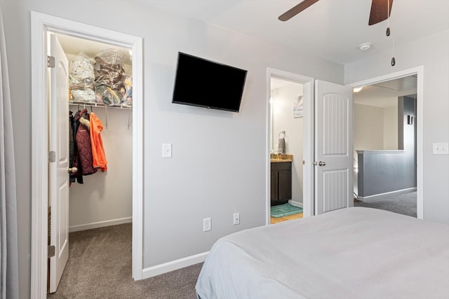 bedroom featuring carpet floors, baseboards, a spacious closet, a closet, and ensuite bath