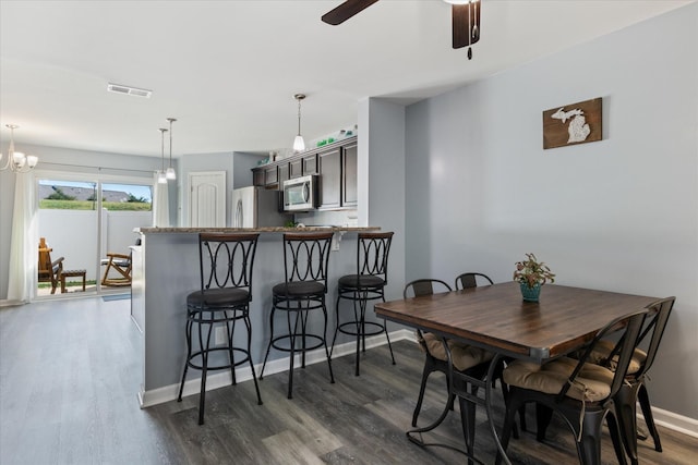 dining space featuring visible vents, dark wood finished floors, baseboards, and ceiling fan