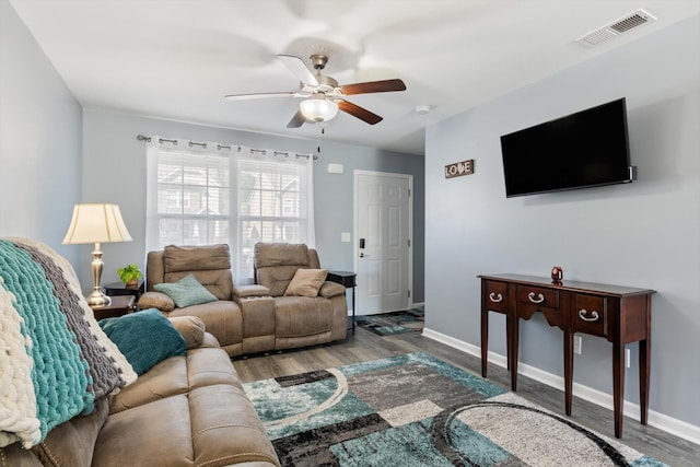 living room with baseboards, ceiling fan, visible vents, and wood finished floors