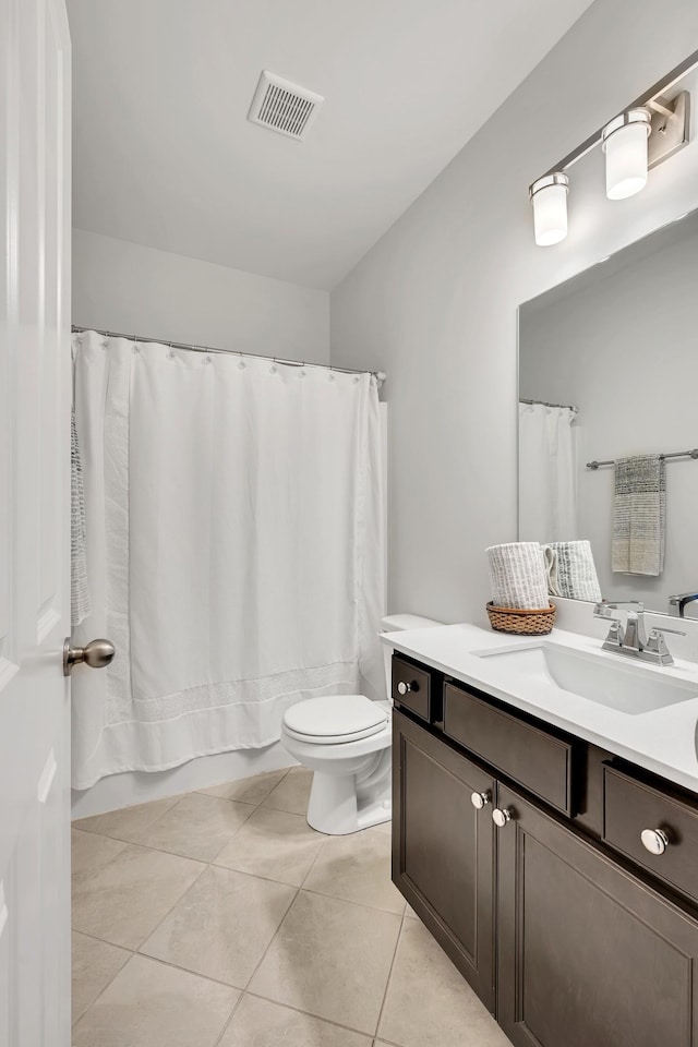 bathroom with toilet, vanity, visible vents, and tile patterned floors