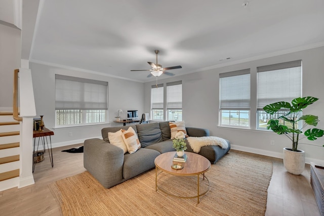 living room featuring baseboards, crown molding, and wood finished floors