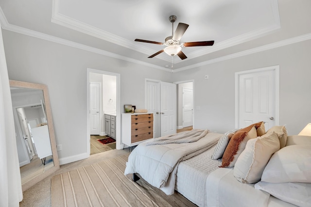 bedroom with ornamental molding, a tray ceiling, baseboards, and light colored carpet