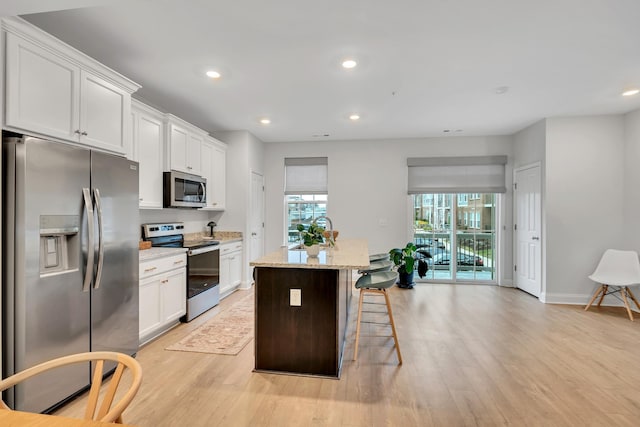 kitchen featuring stainless steel appliances, recessed lighting, a kitchen island, and white cabinets