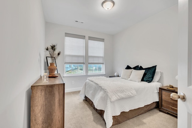 bedroom featuring baseboards, visible vents, and light colored carpet