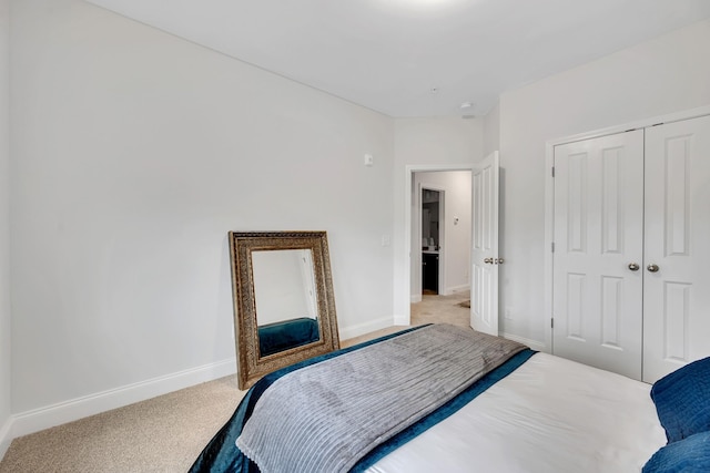 bedroom featuring a closet, light colored carpet, and baseboards