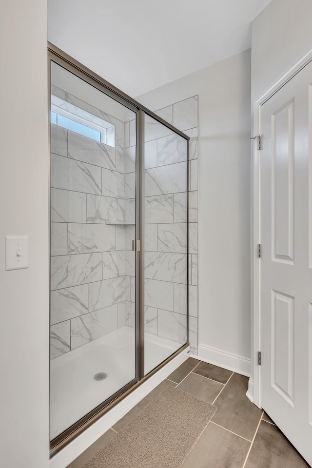 full bath featuring a stall shower and baseboards