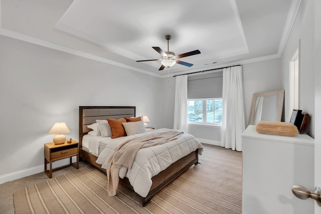 bedroom with ornamental molding, ceiling fan, a tray ceiling, and baseboards