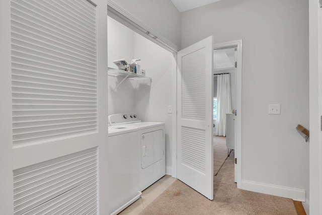 clothes washing area with baseboards, laundry area, separate washer and dryer, and light colored carpet