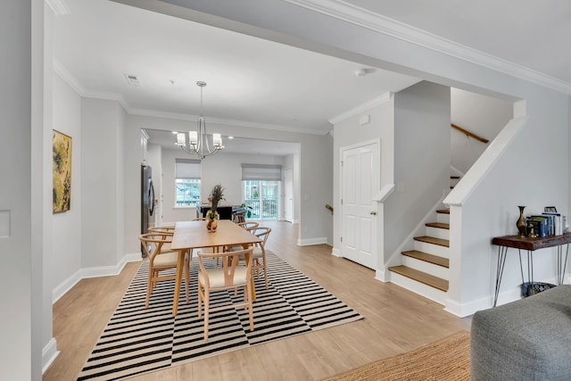 dining room with light wood-style floors, stairway, and ornamental molding