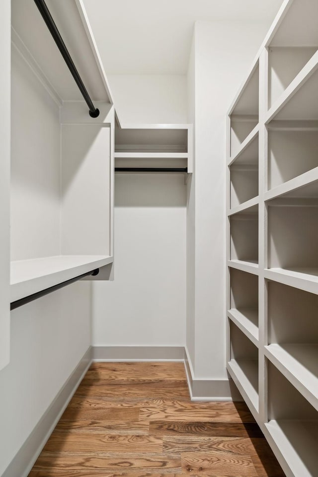 walk in closet with wood finished floors