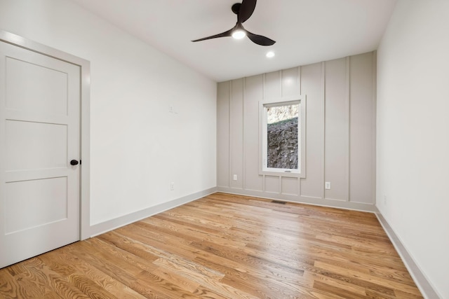 empty room featuring visible vents, light wood finished floors, a ceiling fan, and baseboards