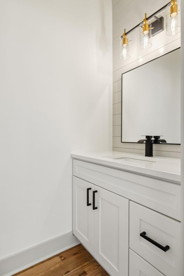 bathroom featuring vanity, baseboards, and wood finished floors