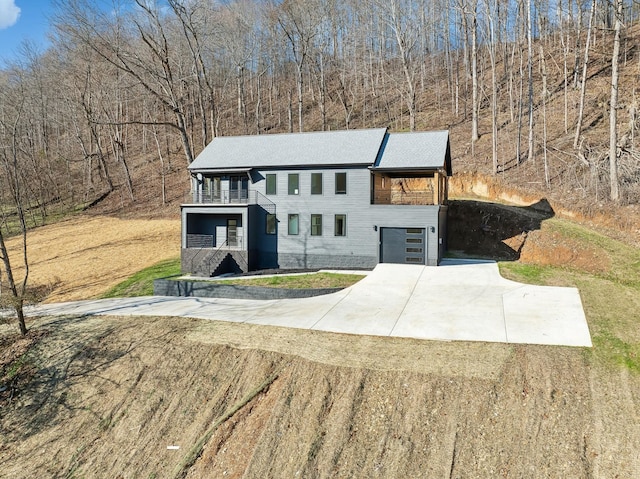 view of front of property featuring a balcony and concrete driveway