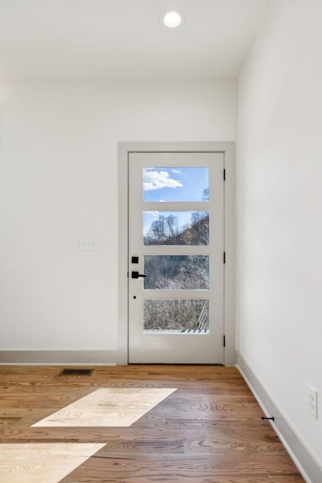 doorway to outside featuring baseboards, wood finished floors, and recessed lighting