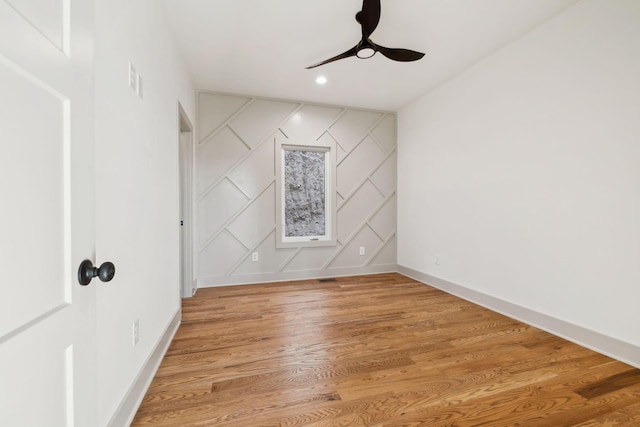 unfurnished room featuring recessed lighting, light wood-style floors, an accent wall, a ceiling fan, and baseboards