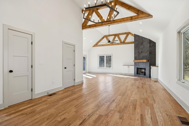 unfurnished living room with a large fireplace, light wood-style flooring, and visible vents