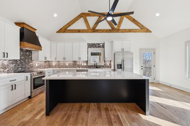 kitchen featuring a center island, light countertops, custom range hood, appliances with stainless steel finishes, and a sink