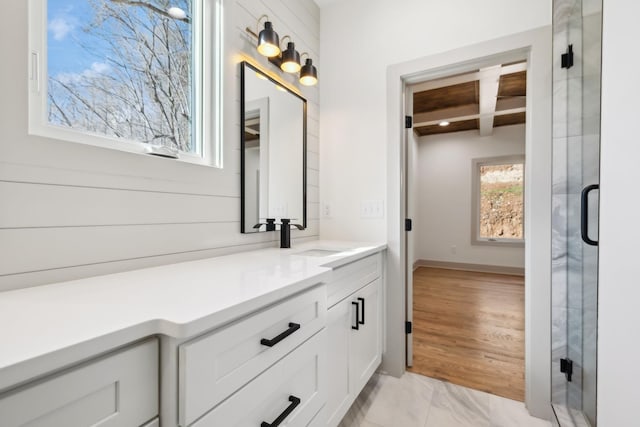 full bathroom featuring marble finish floor, a stall shower, vanity, and baseboards