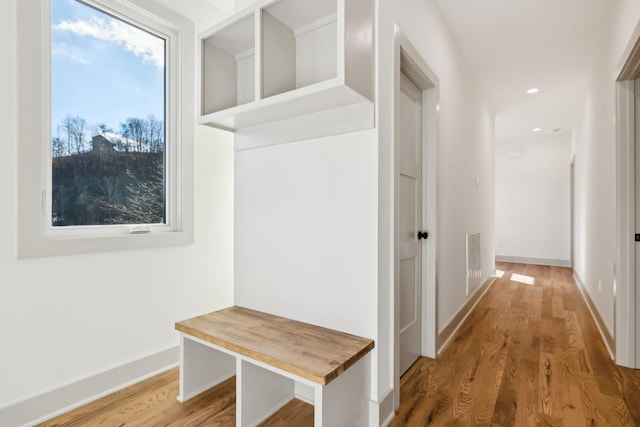 mudroom with recessed lighting, visible vents, baseboards, and wood finished floors