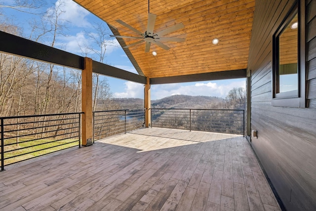 wooden deck with ceiling fan and a mountain view