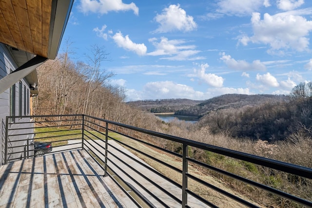 balcony featuring a view of trees and a water and mountain view