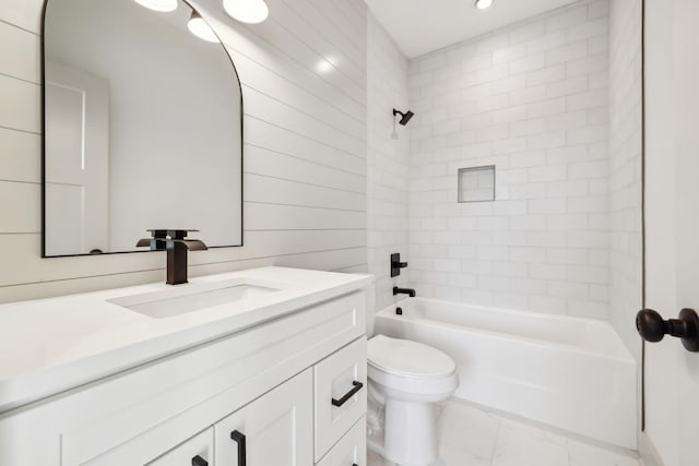 bathroom featuring toilet, marble finish floor, shower / bath combination, and vanity