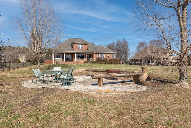 rear view of house featuring fence, a lawn, and a patio