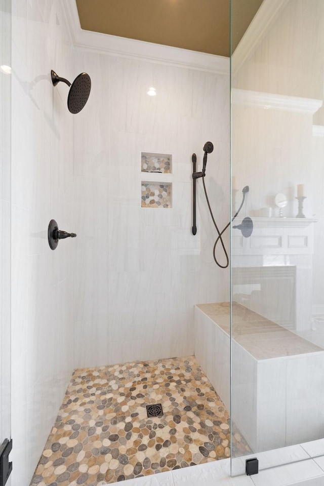 full bath featuring ornamental molding and tiled shower