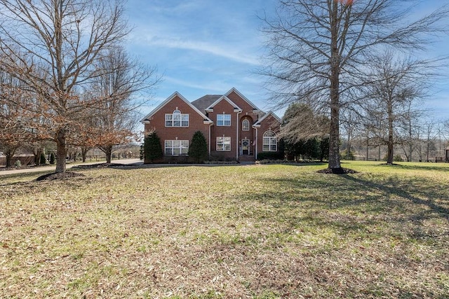 view of front of home featuring brick siding and a front lawn