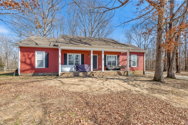 view of front of property featuring driveway, a porch, and crawl space