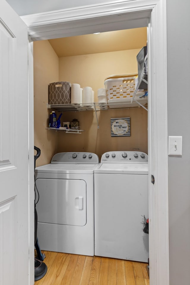 laundry area with light wood-type flooring, laundry area, and washer and dryer