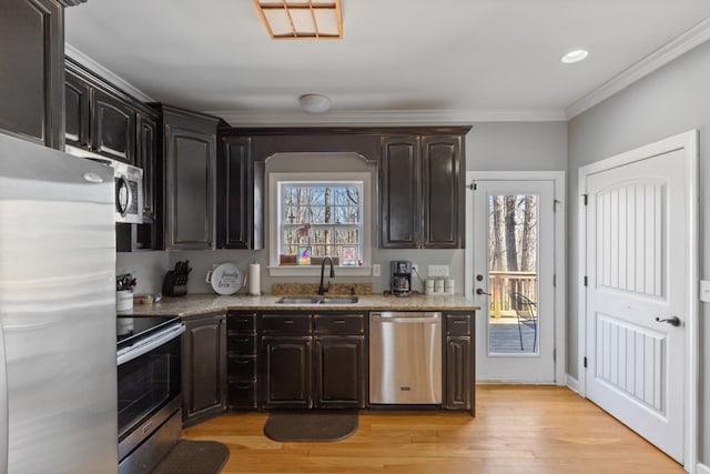 kitchen with light wood finished floors, stainless steel appliances, ornamental molding, a sink, and light stone countertops