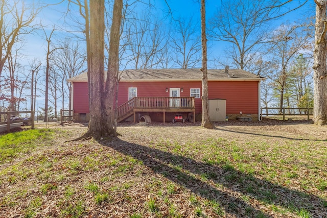 back of property with stairs, fence, a lawn, and a wooden deck