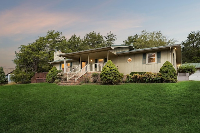 view of front of property featuring a porch, a lawn, and a chimney