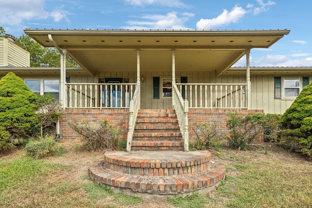 view of front of home with covered porch, board and batten siding, and stairs