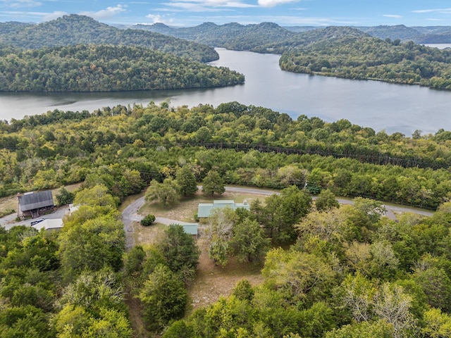 aerial view with a water and mountain view and a wooded view