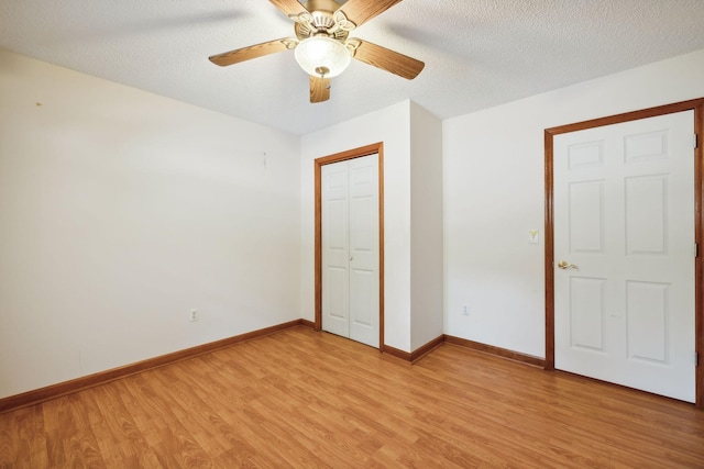 unfurnished bedroom with a textured ceiling, light wood-type flooring, and baseboards