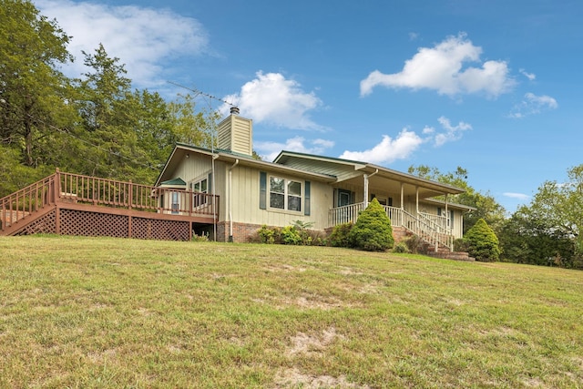 rear view of property featuring a yard, stairway, and a chimney