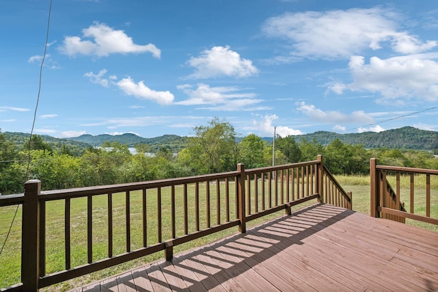 wooden deck with a mountain view and a view of trees