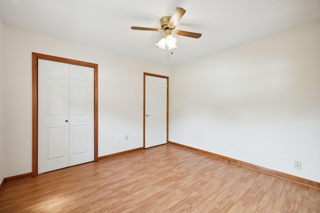 unfurnished bedroom with a ceiling fan, light wood-style flooring, baseboards, and a closet