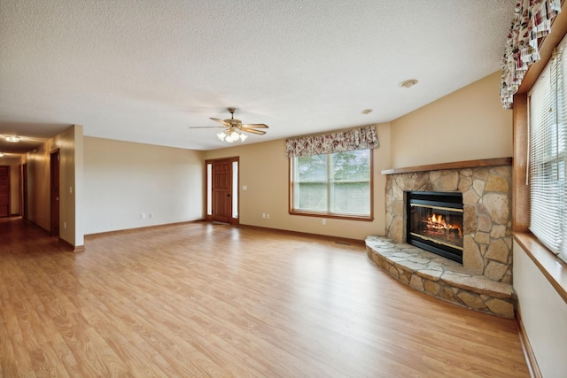 unfurnished living room with a textured ceiling, a fireplace, and wood finished floors