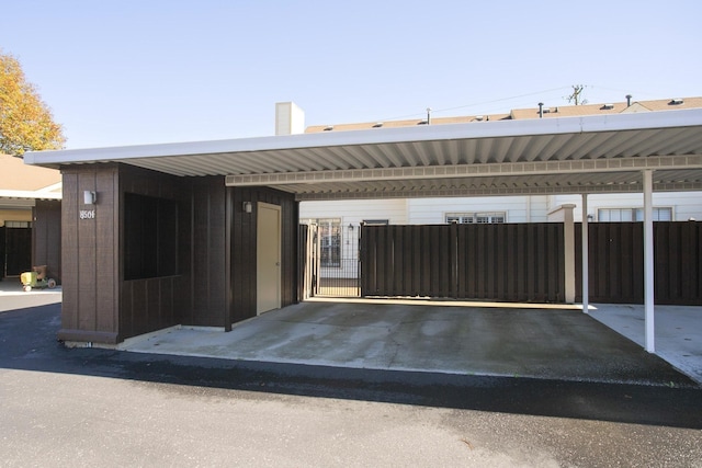 view of front of property featuring covered parking and fence