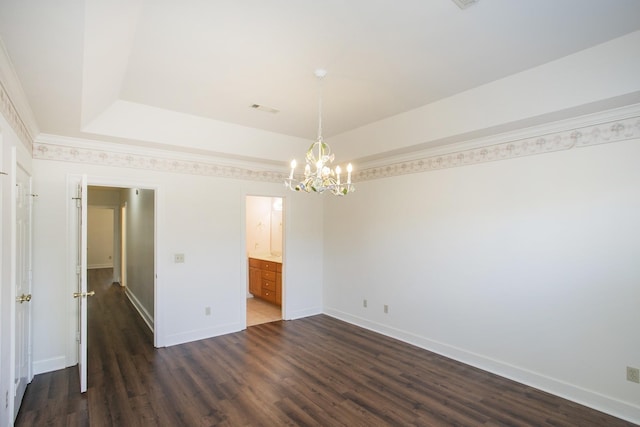 empty room with a raised ceiling, baseboards, a notable chandelier, and dark wood-style flooring