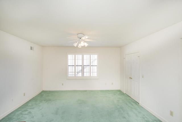 spare room featuring baseboards, visible vents, a ceiling fan, and light colored carpet