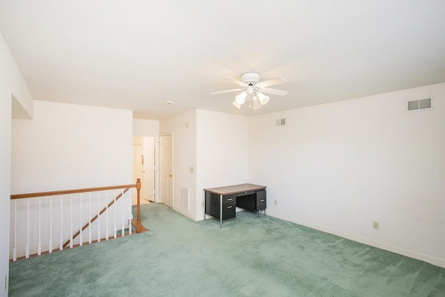 carpeted spare room with visible vents and a ceiling fan