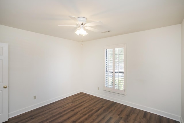 unfurnished room featuring ceiling fan, dark wood finished floors, visible vents, and baseboards